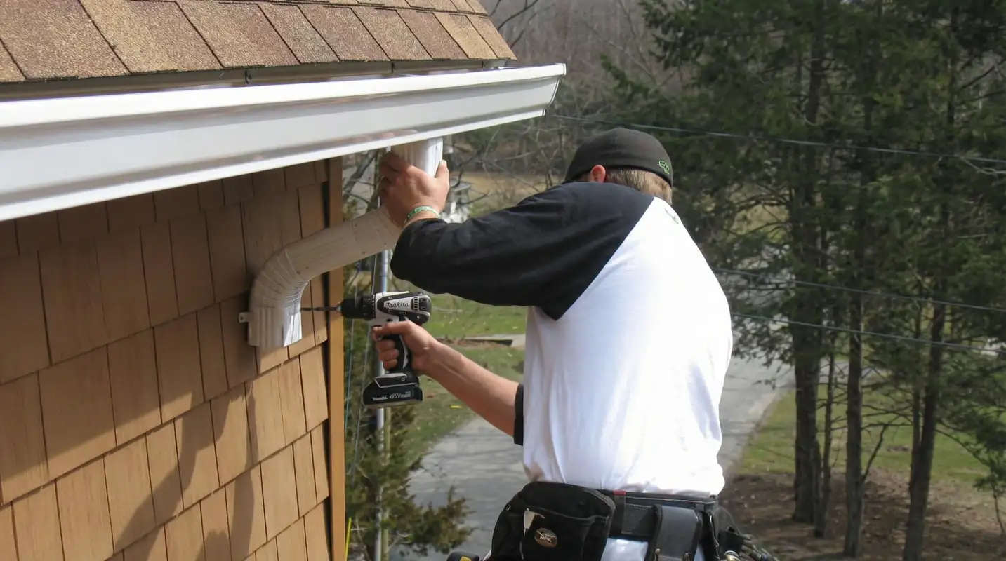 Professional contractor installing tan vinyl siding panels on a residential home exterior in Sacramento, CA